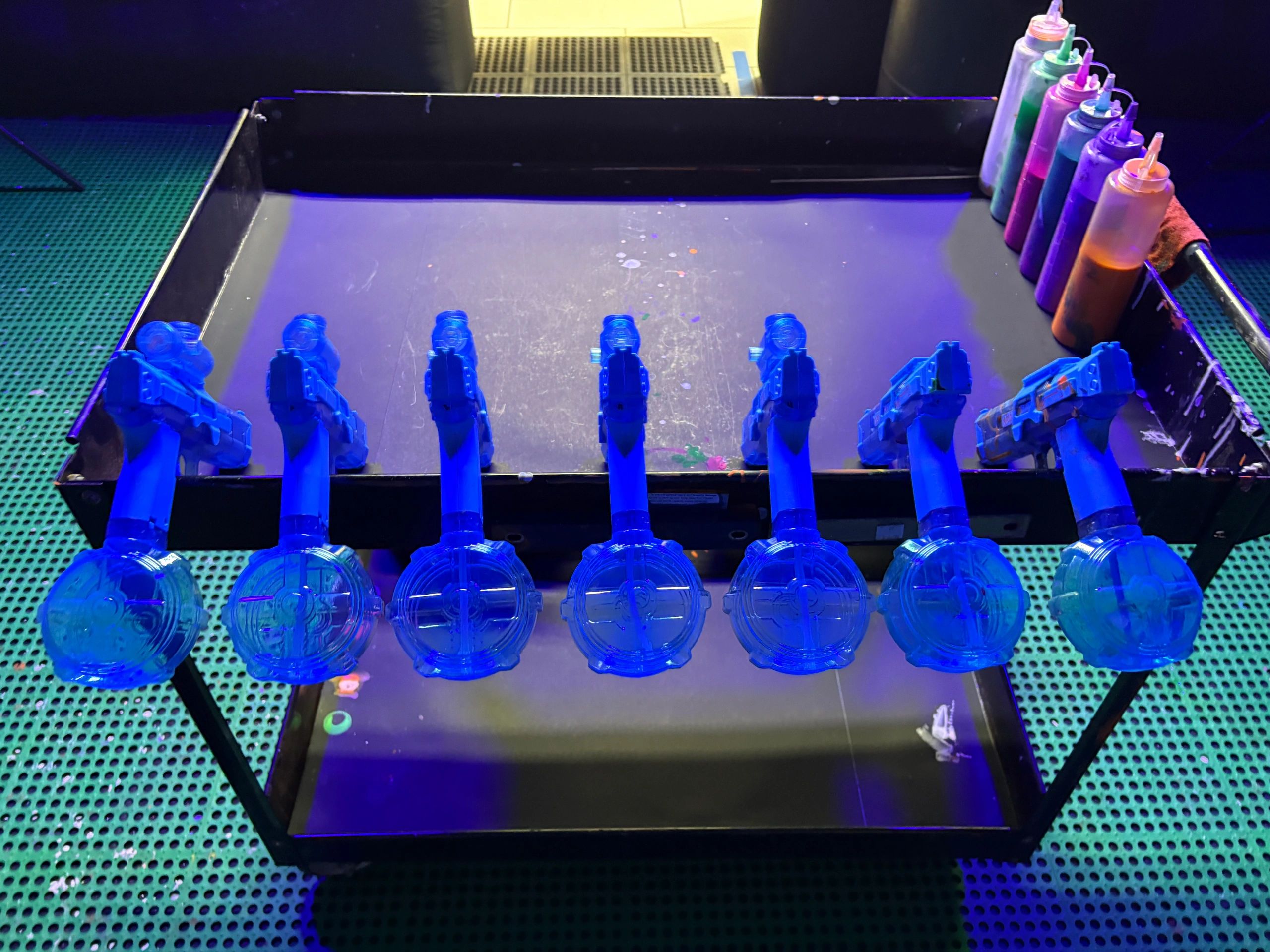 A rainbow of paints under blacklight